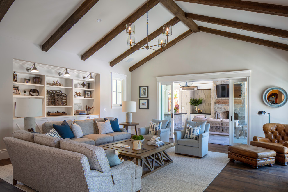 Design ideas for an expansive nautical open plan games room in San Francisco with beige walls, dark hardwood flooring, a standard fireplace, a stone fireplace surround, a wall mounted tv, brown floors and exposed beams.