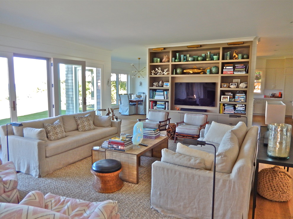 Ejemplo de sala de estar abierta marinera grande sin chimenea con paredes blancas, suelo de madera en tonos medios y pared multimedia