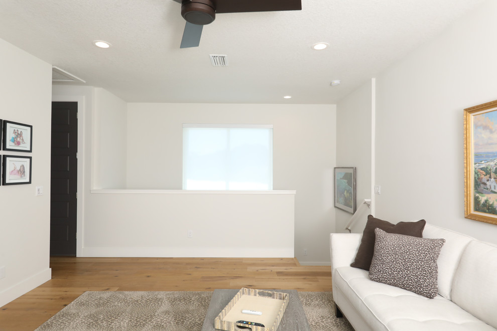 Photo of a medium sized coastal mezzanine games room in Tampa with a reading nook, white walls, light hardwood flooring and a wall mounted tv.