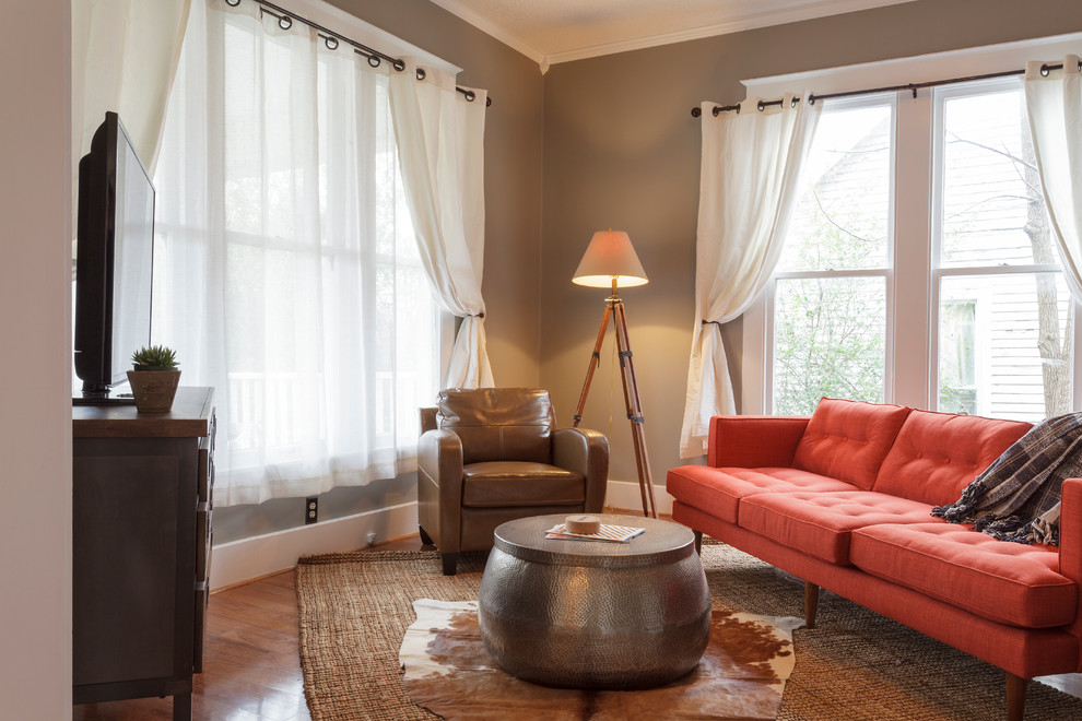 Свежая идея для дизайна: изолированная гостиная комната среднего размера в стиле фьюжн с коричневыми стенами, паркетным полом среднего тона и отдельно стоящим телевизором - отличное фото интерьера