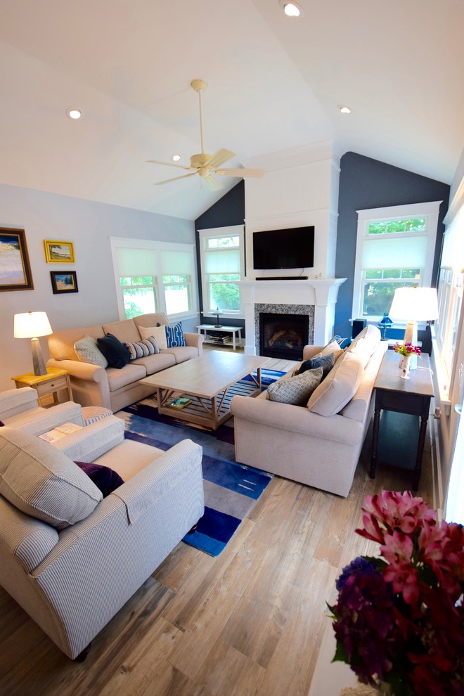 Источник вдохновения для домашнего уюта: большая изолированная гостиная комната с серыми стенами, полом из керамогранита, стандартным камином, фасадом камина из дерева, телевизором на стене и разноцветным полом