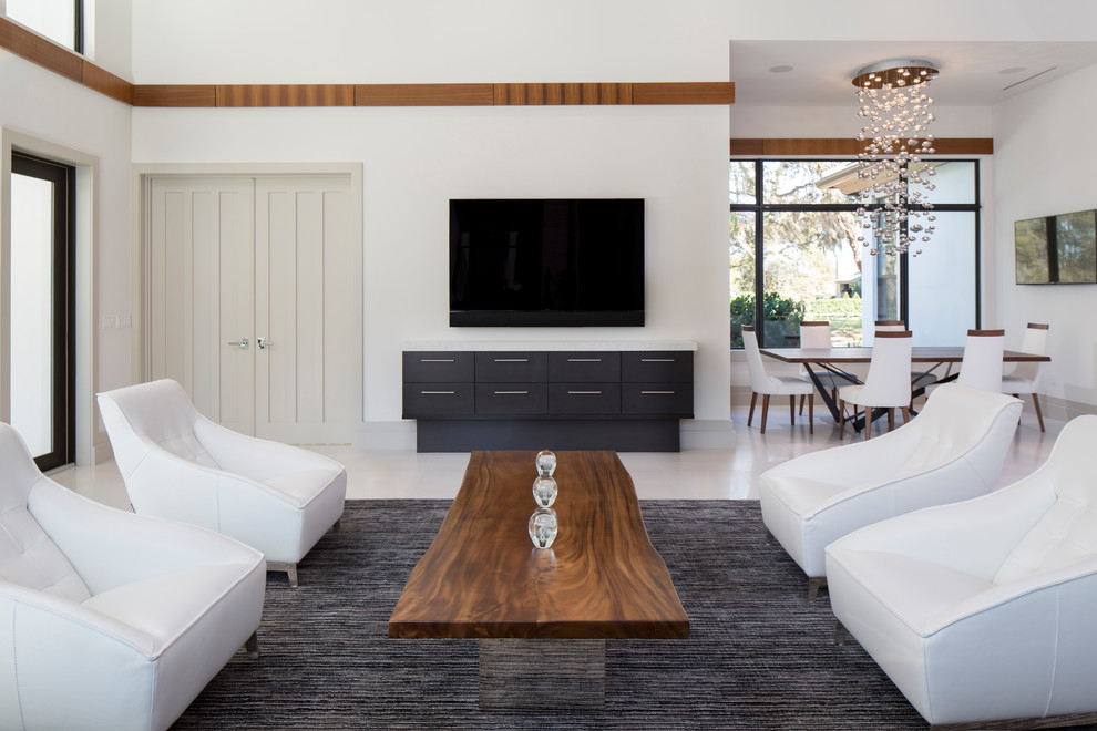 Modelo de sala de estar abierta minimalista grande sin chimenea con paredes blancas, televisor colgado en la pared, suelo de mármol y suelo blanco