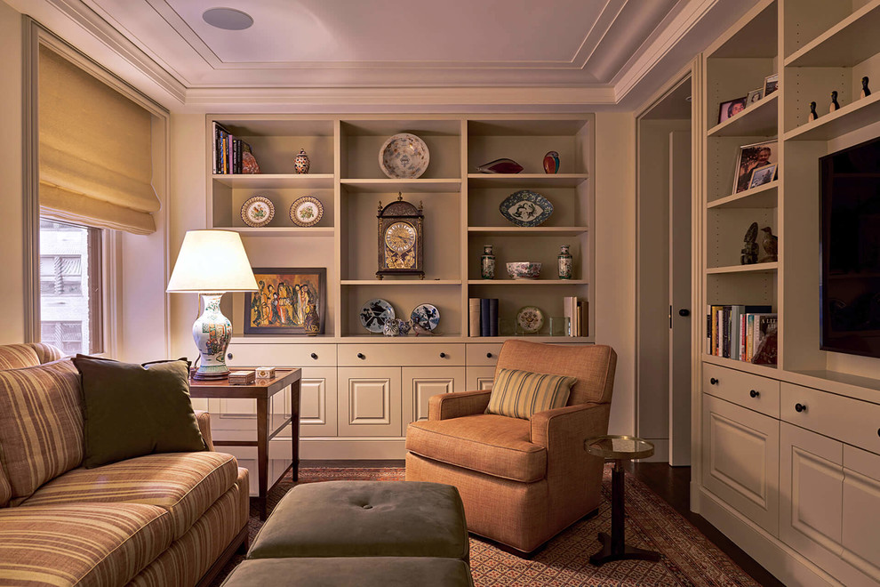 Example of a mid-sized classic enclosed dark wood floor and brown floor family room library design in New York with beige walls, no fireplace and a media wall