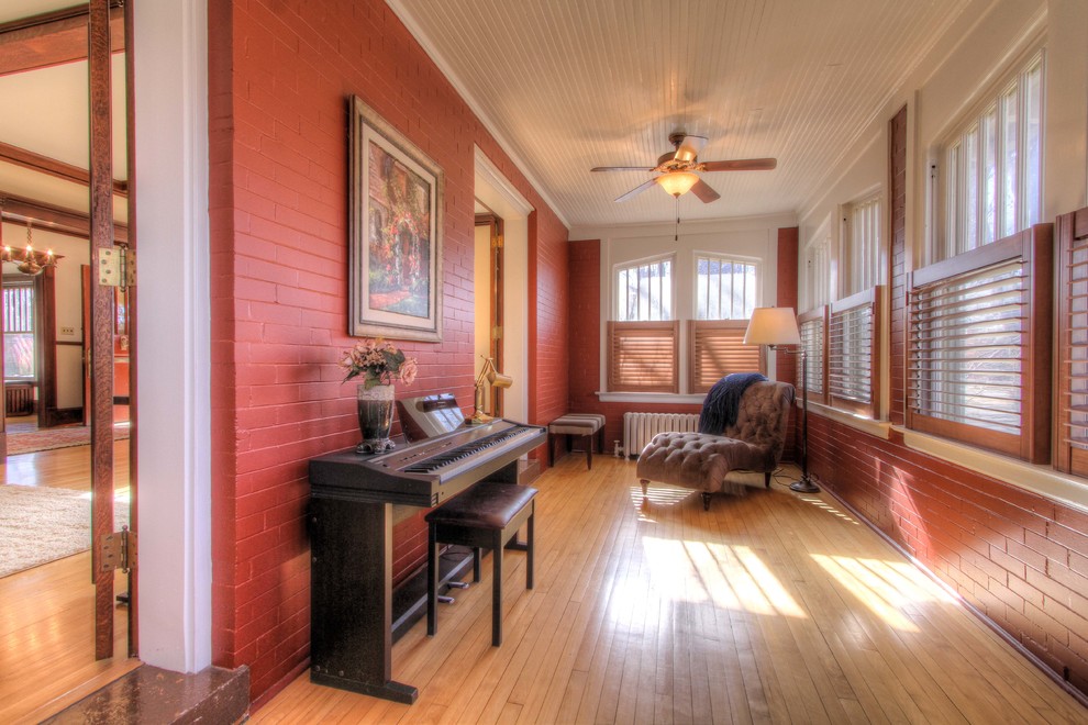 Medium sized classic enclosed games room in Raleigh with a music area, red walls and light hardwood flooring.