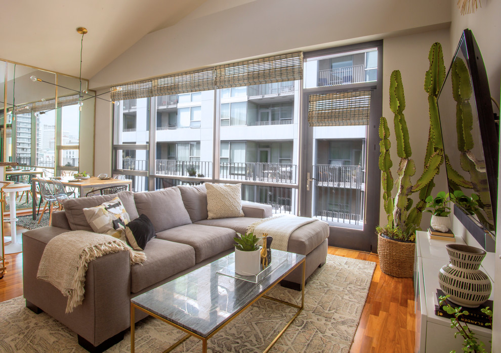 Inspiration for a mid-sized scandinavian open concept medium tone wood floor and brown floor family room remodel in San Diego with gray walls, no fireplace and a wall-mounted tv