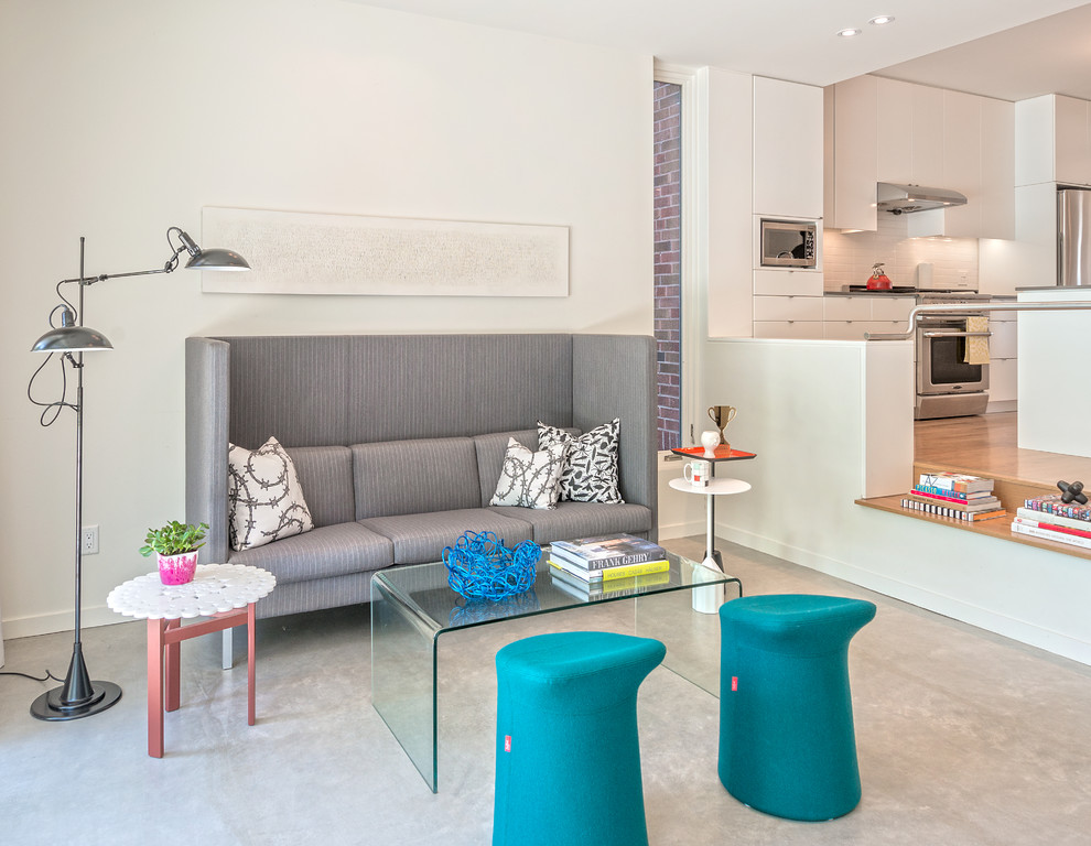 Стильный дизайн: открытая гостиная комната в современном стиле с белыми стенами и бетонным полом без камина - последний тренд