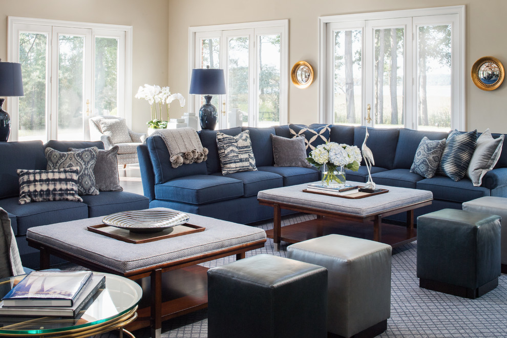 На фото: гостиная комната в классическом стиле с бежевыми стенами и синим диваном с