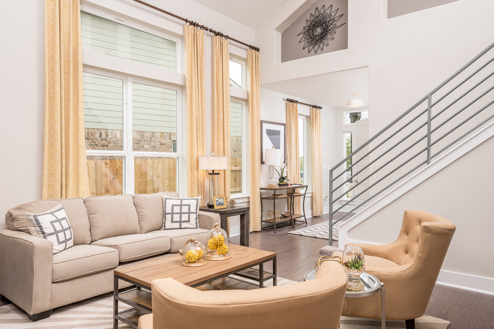 Imagen de sala de estar abierta contemporánea de tamaño medio sin chimenea con paredes grises, suelo de madera en tonos medios, marco de chimenea de yeso y televisor colgado en la pared