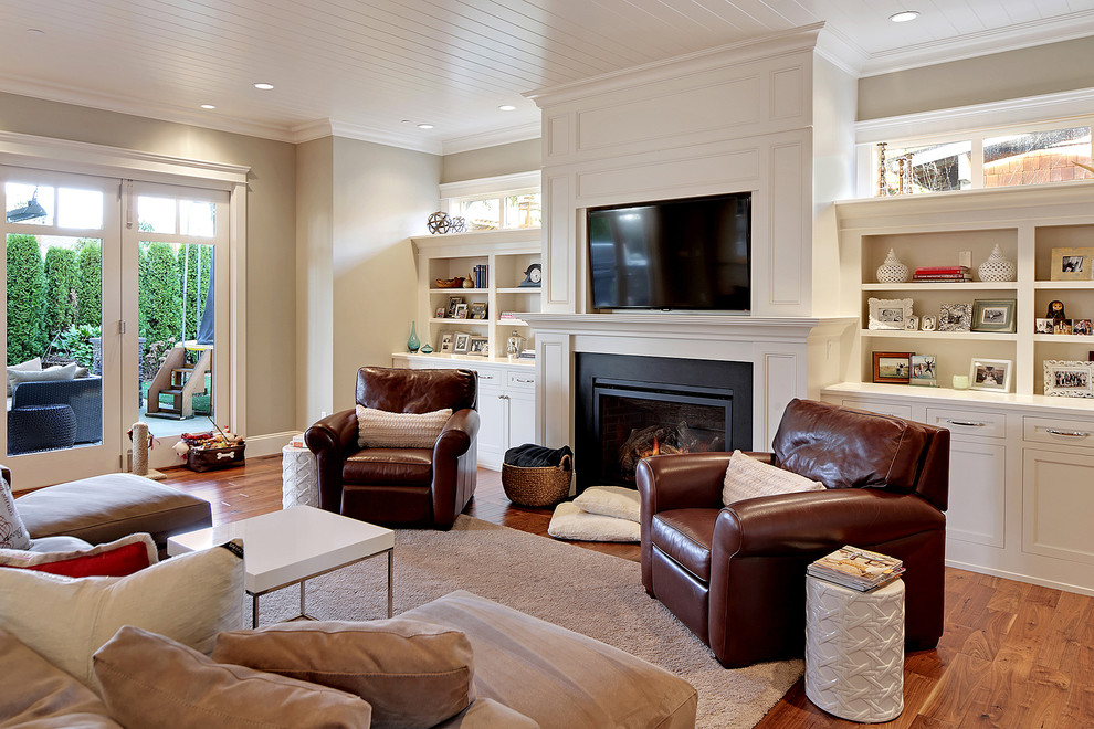 Imagen de sala de estar abierta tradicional renovada grande con paredes beige, suelo de madera en tonos medios, todas las chimeneas, marco de chimenea de metal y pared multimedia