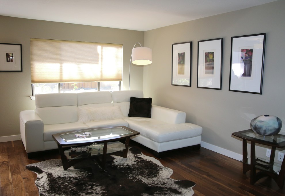 Imagen de sala de estar tipo loft contemporánea de tamaño medio con paredes grises, marco de chimenea de baldosas y/o azulejos y televisor retractable