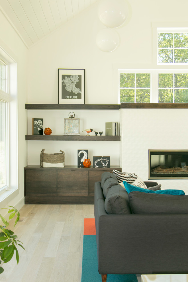 Cette photo montre une salle de séjour tendance avec un mur blanc, parquet clair, une cheminée standard, un manteau de cheminée en carrelage et un sol bleu.