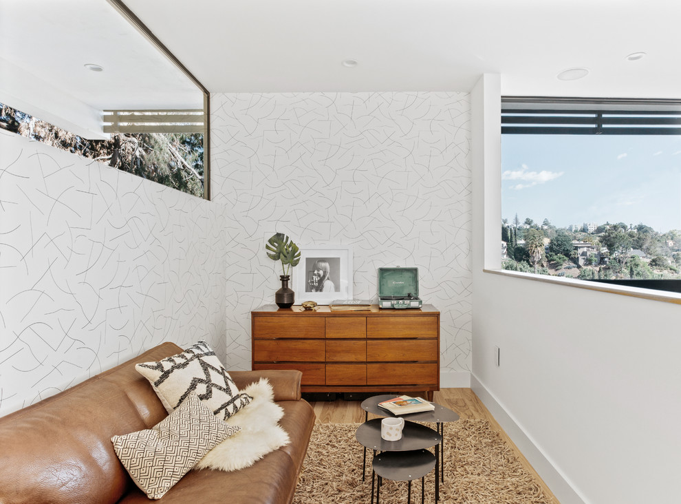 ロサンゼルスにある小さなコンテンポラリースタイルのおしゃれなロフトリビング (白い壁、無垢フローリング、茶色い床) の写真