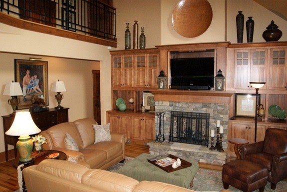 Inspiration pour une salle de séjour craftsman de taille moyenne et ouverte avec un mur beige, un sol en bois brun, une cheminée standard, un manteau de cheminée en pierre et un téléviseur encastré.