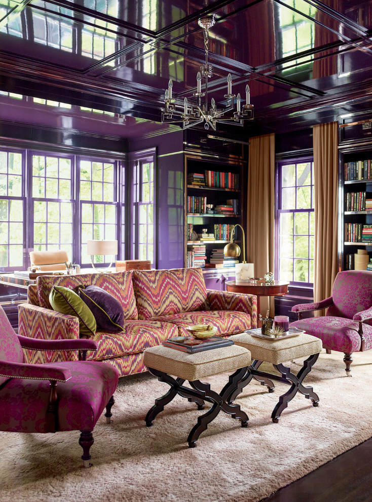 Diseño de sala de estar con biblioteca ecléctica con paredes púrpuras y suelo de madera oscura