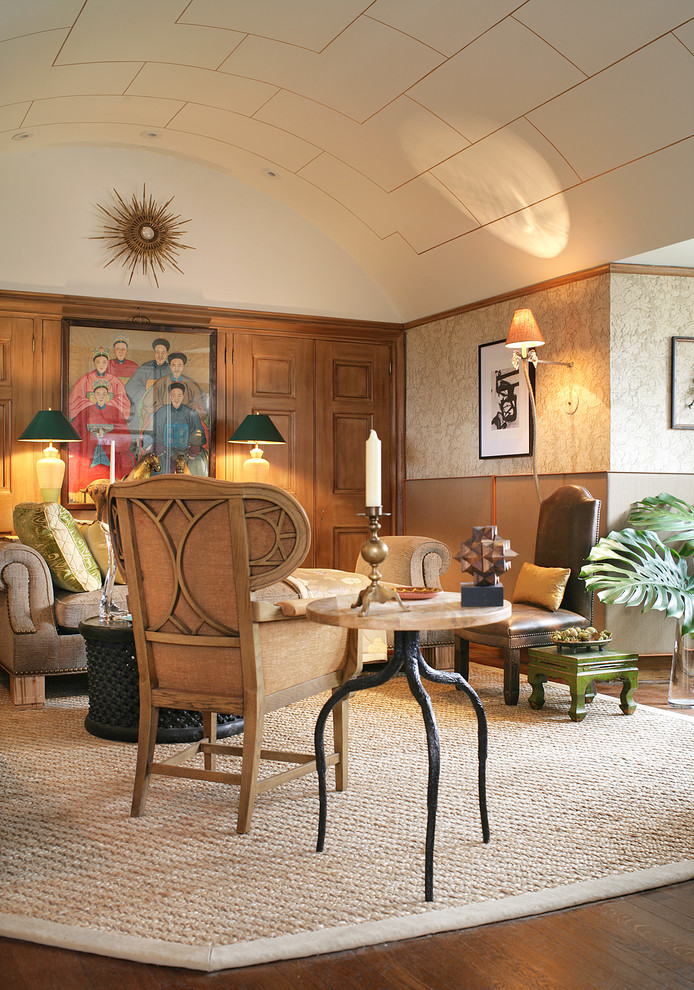 Modelo de sala de estar con biblioteca cerrada bohemia de tamaño medio con paredes beige, suelo de madera oscura y alfombra