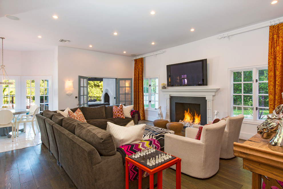 Medium sized bohemian enclosed games room in Los Angeles with white walls, medium hardwood flooring, a standard fireplace, a stone fireplace surround and a wall mounted tv.