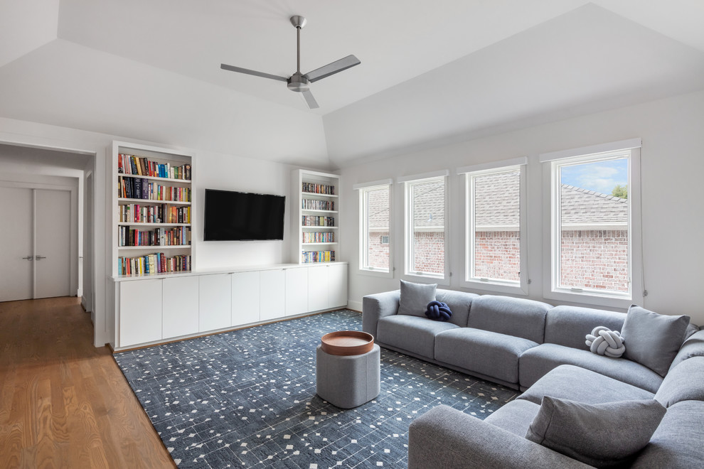 Foto di un soggiorno moderno di medie dimensioni e stile loft con sala giochi, pareti bianche, pavimento in legno massello medio, TV a parete e pavimento marrone