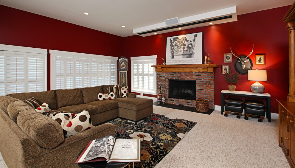 Пример оригинального дизайна: большая открытая гостиная комната в классическом стиле с красными стенами, ковровым покрытием, стандартным камином, фасадом камина из кирпича и мультимедийным центром