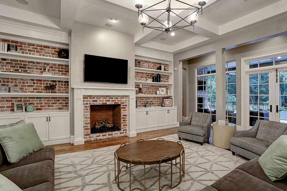 Großes, Offenes Landhausstil Wohnzimmer mit beiger Wandfarbe, braunem Holzboden, Kamin, Kaminumrandung aus Holz, TV-Wand und braunem Boden in Houston