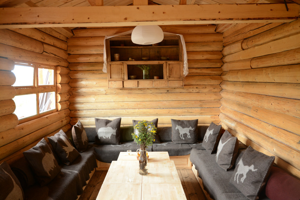 This is an example of a small rustic enclosed games room in Other with light hardwood flooring, brown walls, no fireplace, no tv and brown floors.