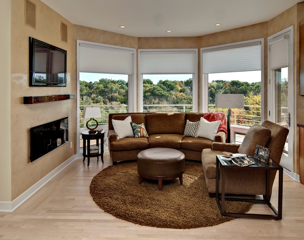 Пример оригинального дизайна: изолированная гостиная комната в стиле неоклассика (современная классика) с бежевыми стенами, светлым паркетным полом, горизонтальным камином, телевизором на стене и коричневым диваном