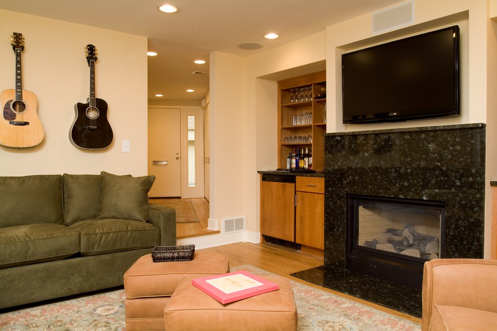 Exempel på ett mellanstort modernt avskilt allrum, med en hemmabar, beige väggar, ljust trägolv, en standard öppen spis, en spiselkrans i sten och en väggmonterad TV