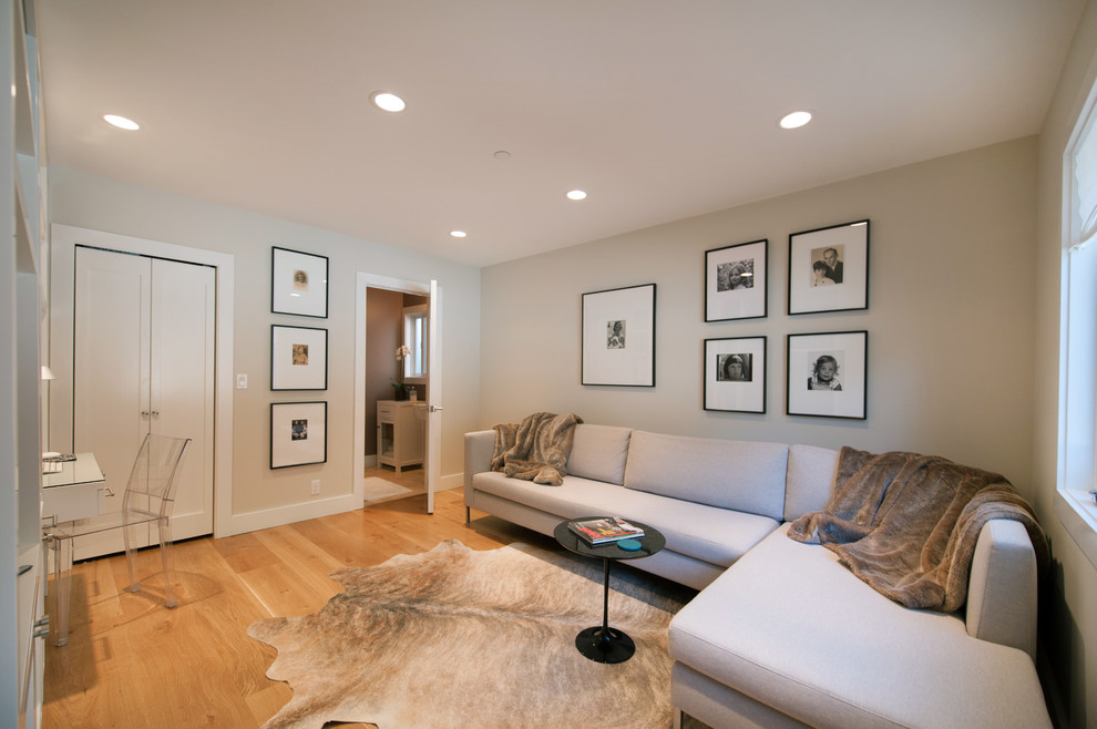Family room - contemporary enclosed medium tone wood floor family room idea in San Francisco with beige walls