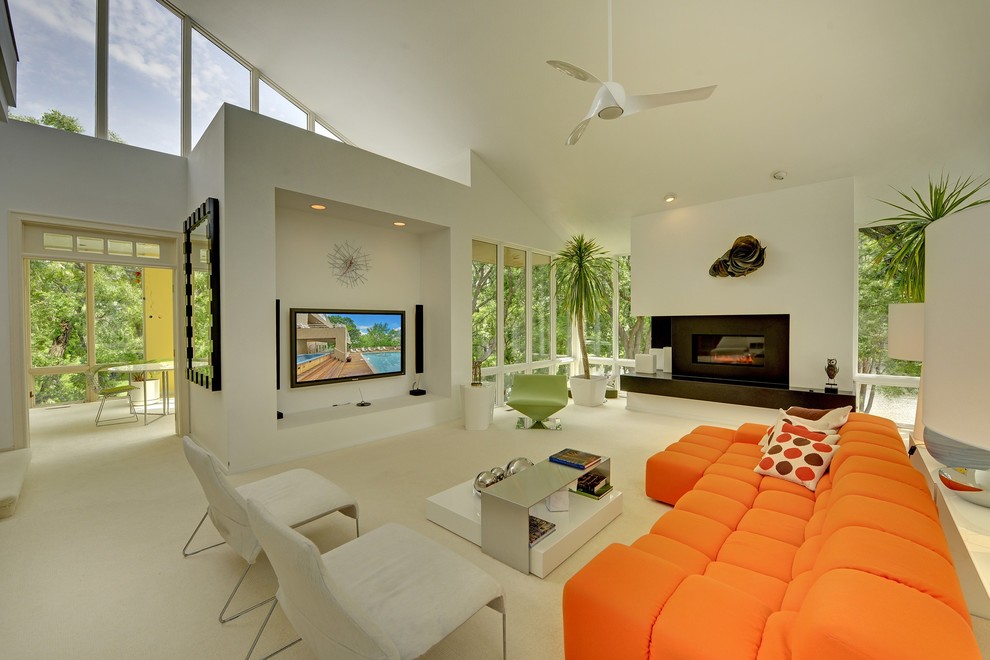Источник вдохновения для домашнего уюта: открытая гостиная комната в современном стиле с бежевыми стенами, стандартным камином и телевизором на стене
