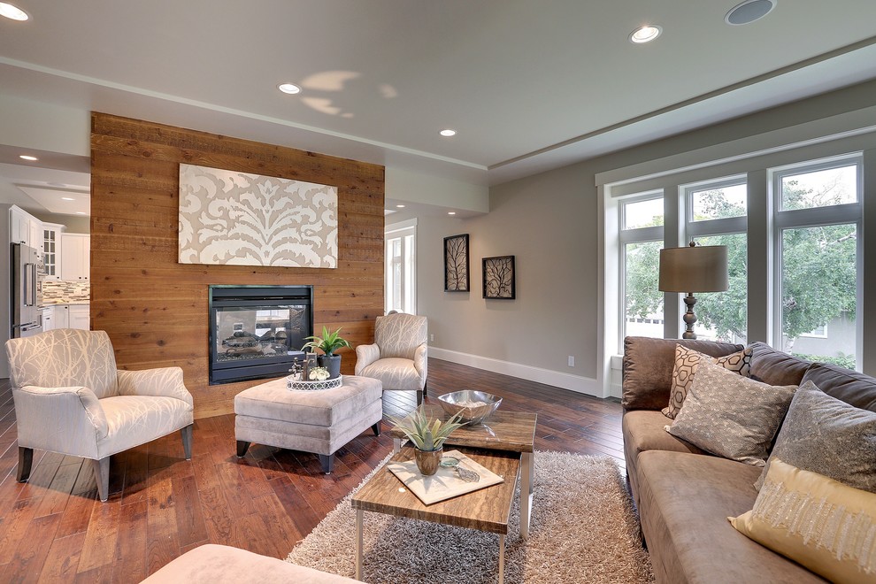 Example of a mid-sized mountain style open concept dark wood floor and brown floor family room design in Minneapolis with white walls, a two-sided fireplace and a metal fireplace