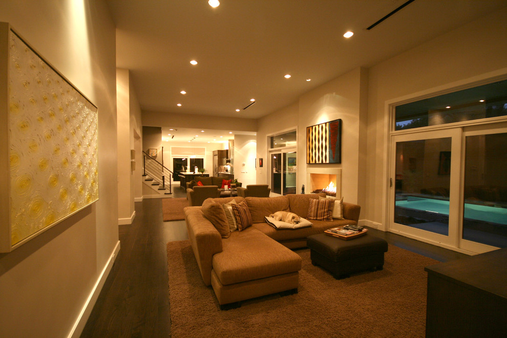 Imagen de sala de estar abierta contemporánea con paredes beige y suelo de madera oscura
