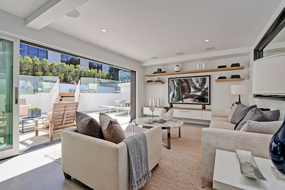 Ejemplo de sala de estar con barra de bar abierta actual de tamaño medio con paredes blancas, suelo de madera clara, televisor colgado en la pared y alfombra