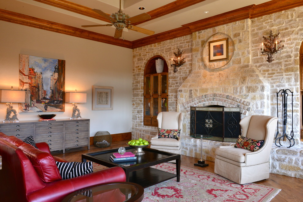 Cette photo montre une salle de séjour chic ouverte avec un sol en bois brun, une cheminée standard et un manteau de cheminée en pierre.
