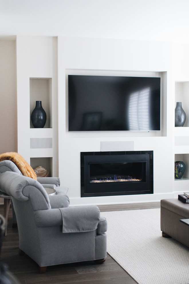 Aménagement d'une salle de séjour classique de taille moyenne et ouverte avec un mur gris, un sol en bois brun, un téléviseur encastré et un sol marron.
