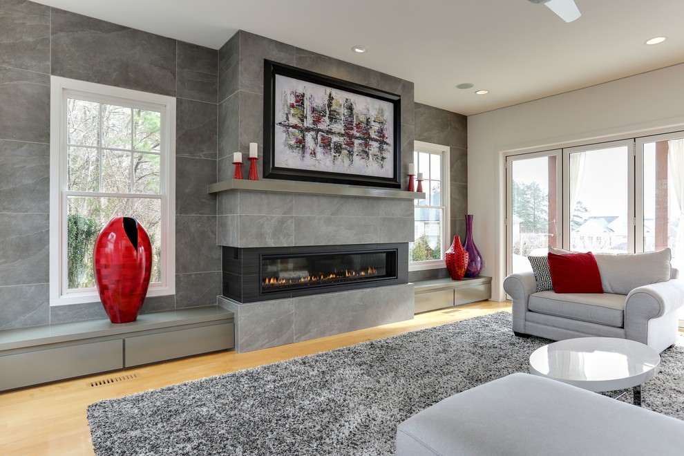Diseño de sala de estar contemporánea grande con paredes grises, suelo de madera clara, chimenea lineal, suelo beige y alfombra
