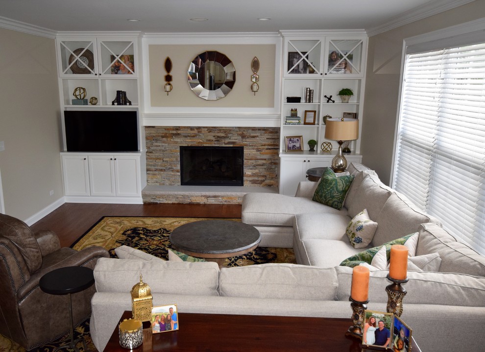 Example of a mid-sized transitional open concept medium tone wood floor family room library design in Chicago with beige walls, a standard fireplace, a stone fireplace and a media wall