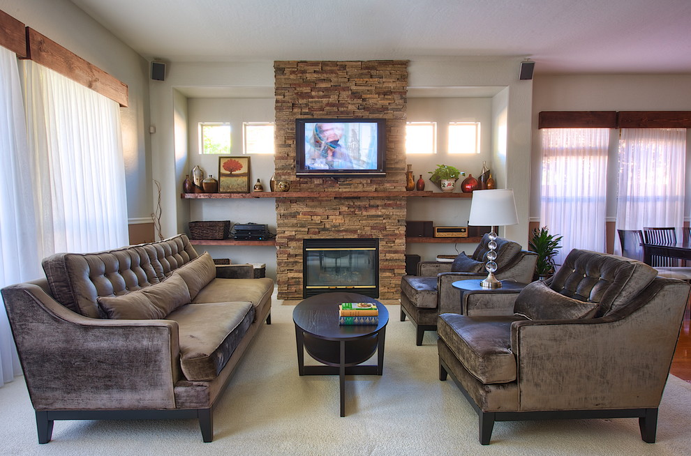 Imagen de sala de estar abierta contemporánea de tamaño medio con todas las chimeneas, marco de chimenea de piedra, televisor colgado en la pared, paredes beige y moqueta