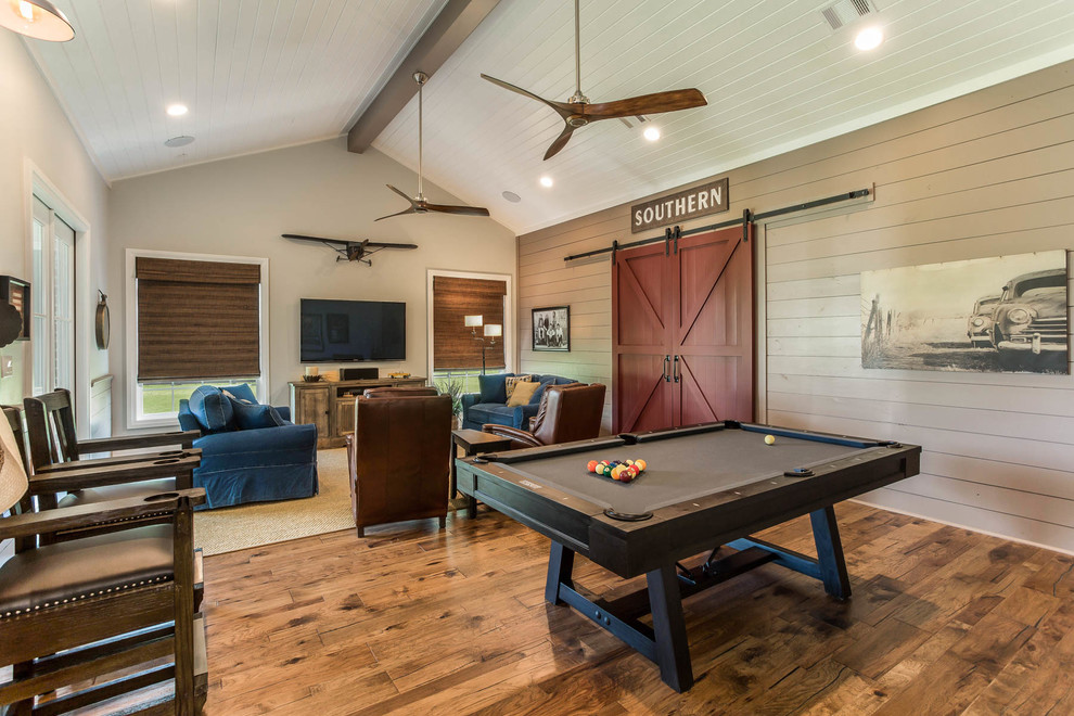 Foto di un soggiorno country aperto con sala giochi, pareti beige, pavimento in legno massello medio, TV a parete e pavimento marrone