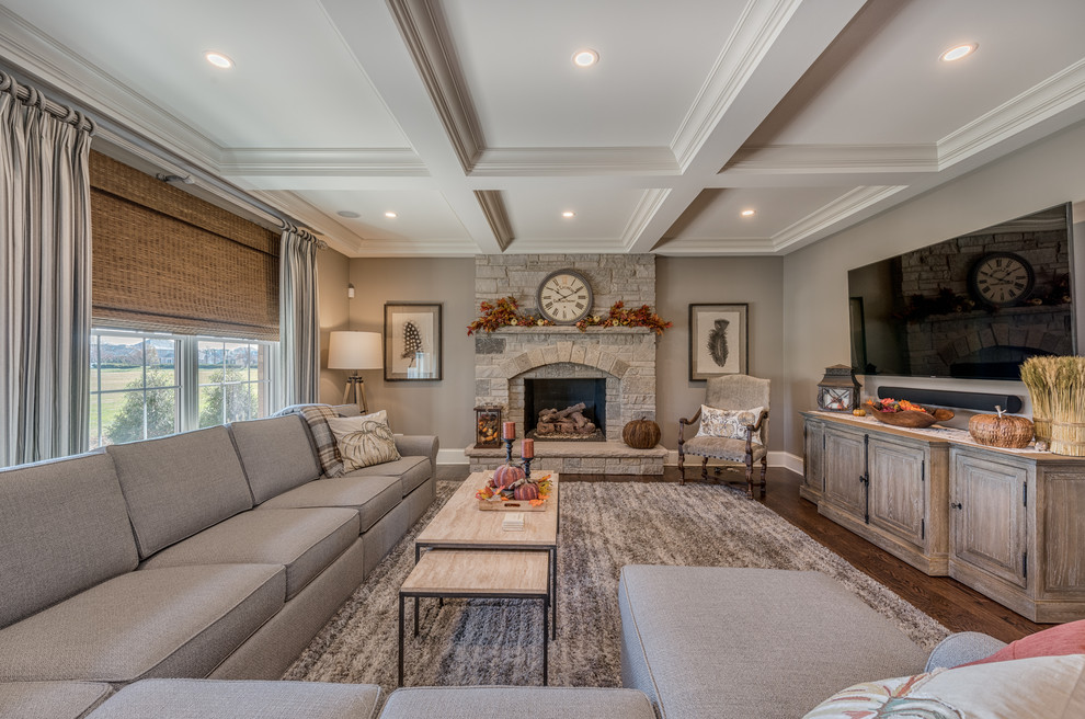Inspiration for a large traditional mezzanine games room in Chicago with grey walls, dark hardwood flooring, a standard fireplace, a stone fireplace surround, a wall mounted tv and brown floors.