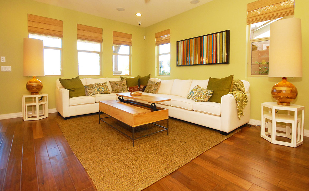 Mittelgroßes, Offenes Modernes Wohnzimmer mit grüner Wandfarbe, dunklem Holzboden und Multimediawand in Phoenix