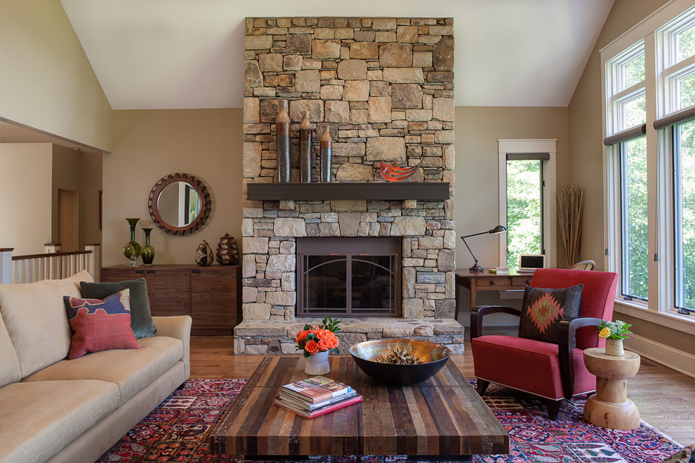 Fernseherloses Klassisches Wohnzimmer mit beiger Wandfarbe, braunem Holzboden, Kamin und Kaminumrandung aus Stein in Sonstige