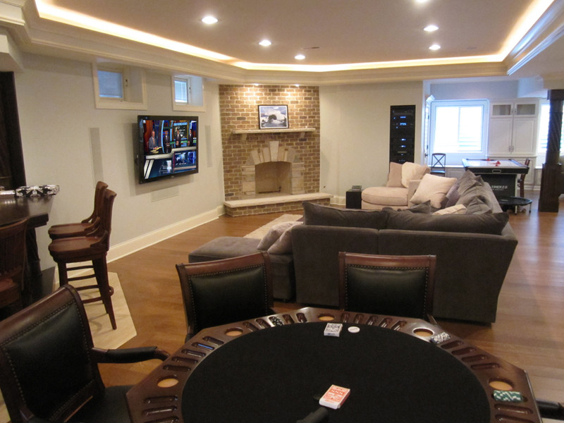 Пример оригинального дизайна: открытая комната для игр среднего размера в классическом стиле с белыми стенами, фасадом камина из кирпича, паркетным полом среднего тона, угловым камином, телевизором на стене и коричневым полом