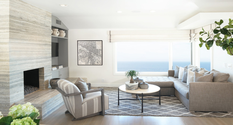 Идея дизайна: открытая гостиная комната в морском стиле с белыми стенами, паркетным полом среднего тона, стандартным камином, фасадом камина из камня, мультимедийным центром, коричневым полом и ковром на полу