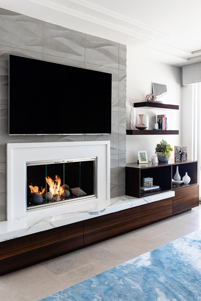 Design ideas for a medium sized modern open plan games room in San Diego with white walls, limestone flooring, a standard fireplace, a stone fireplace surround, a built-in media unit and grey floors.