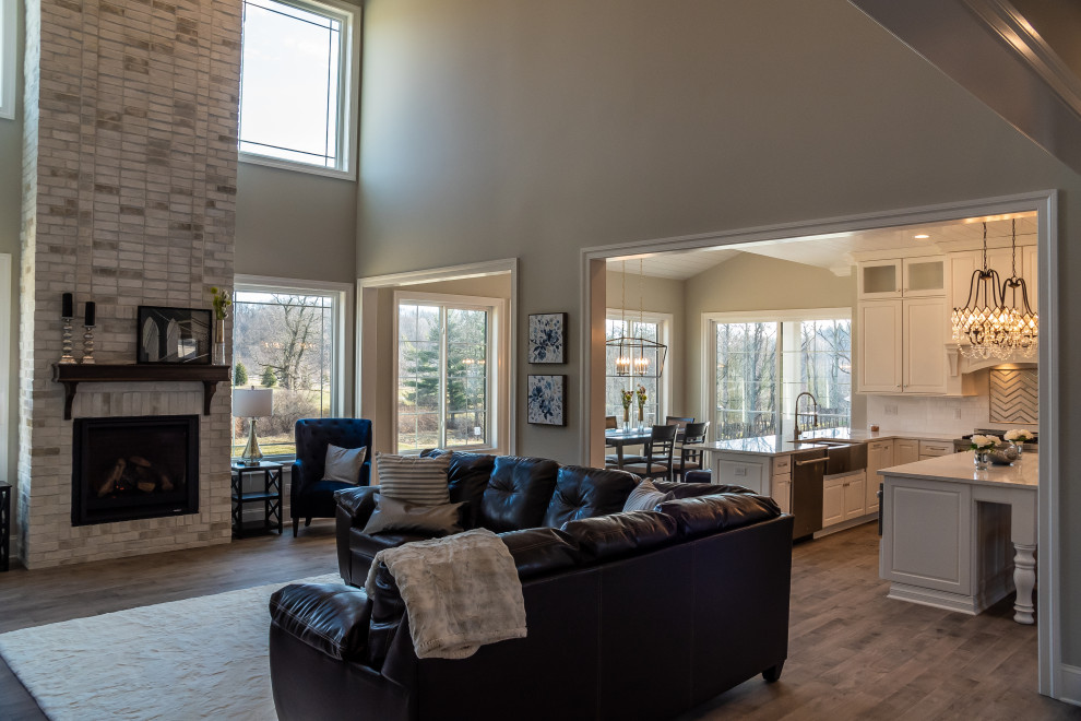 Exemple d'une salle de séjour romantique ouverte avec un mur gris, parquet clair, une cheminée standard, un manteau de cheminée en brique et un plafond à caissons.