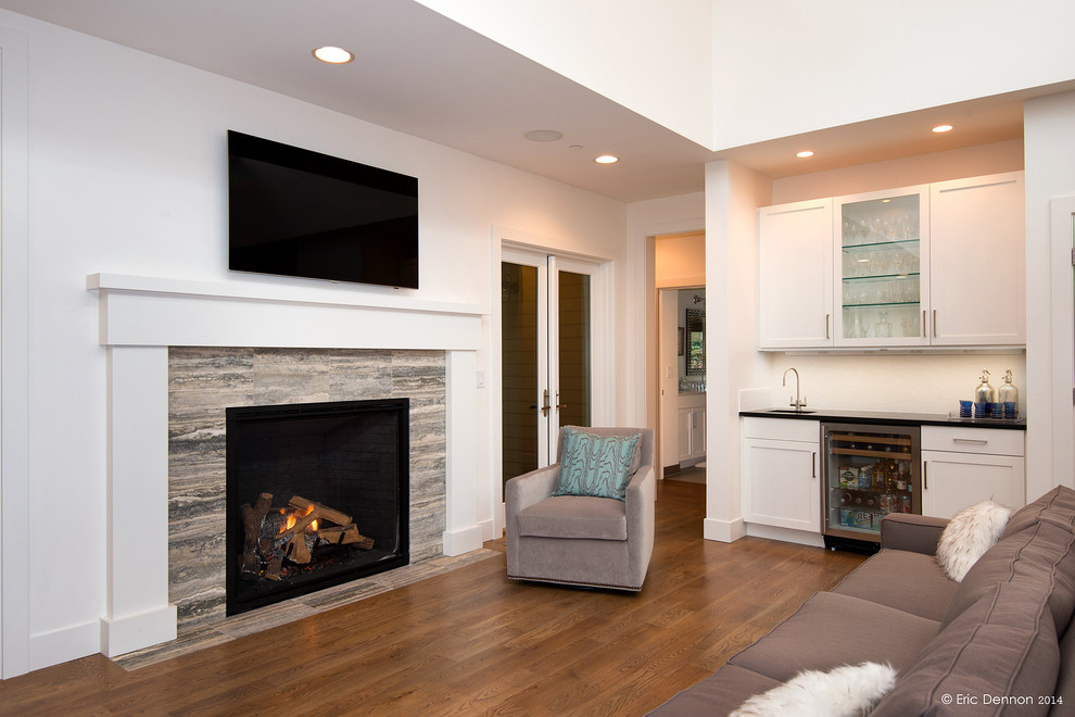 Exempel på ett stort modernt allrum med öppen planlösning, med vita väggar, mellanmörkt trägolv, en väggmonterad TV, en hemmabar, en spiselkrans i trä och en standard öppen spis