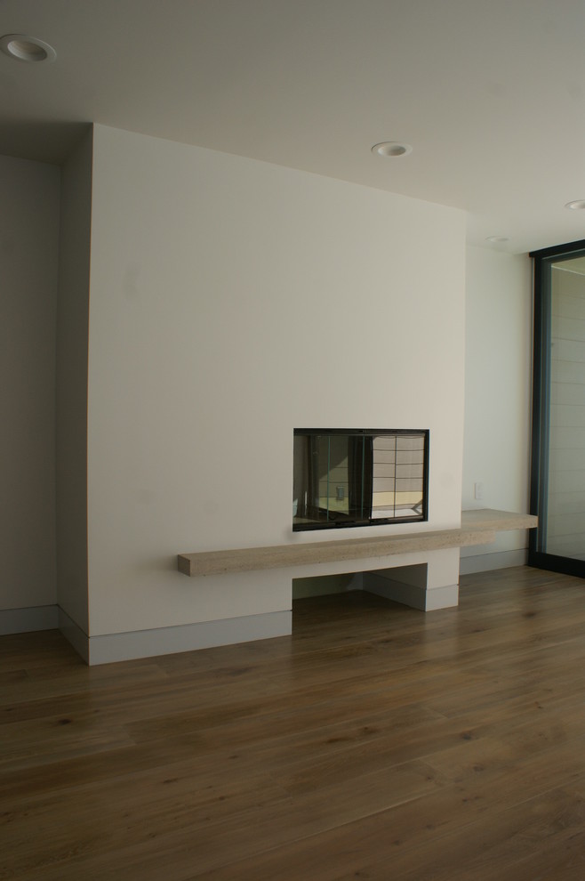 На фото: большая открытая гостиная комната в стиле модернизм с белыми стенами, светлым паркетным полом и стандартным камином с