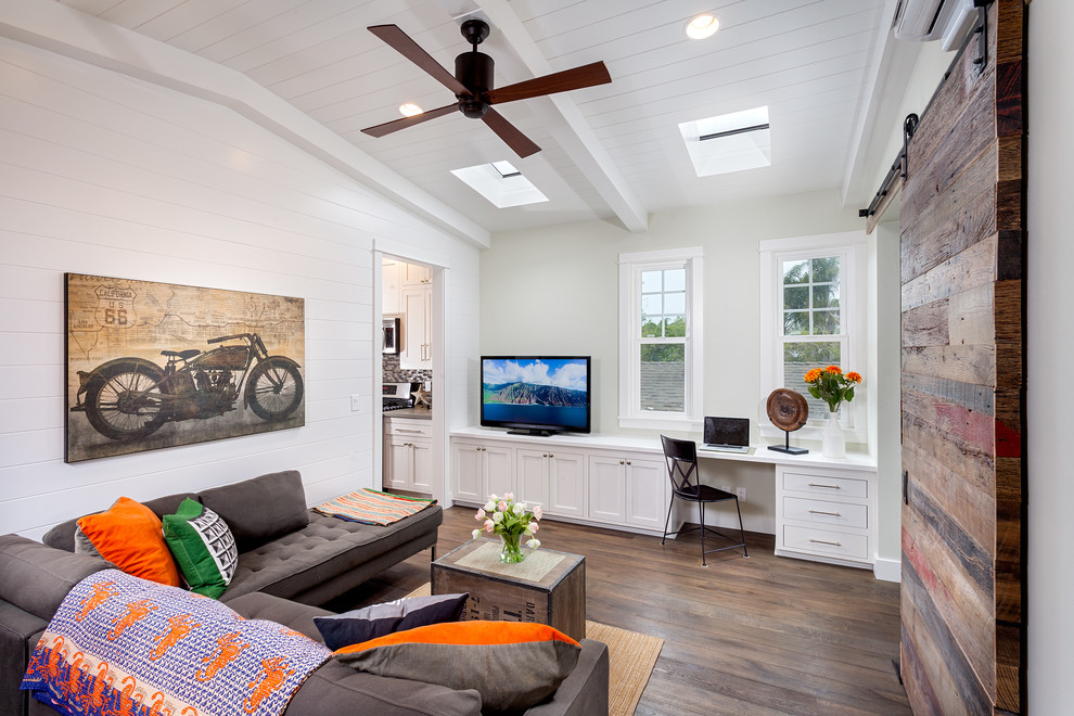 Abgetrenntes Modernes Wohnzimmer mit weißer Wandfarbe, dunklem Holzboden und freistehendem TV in San Diego