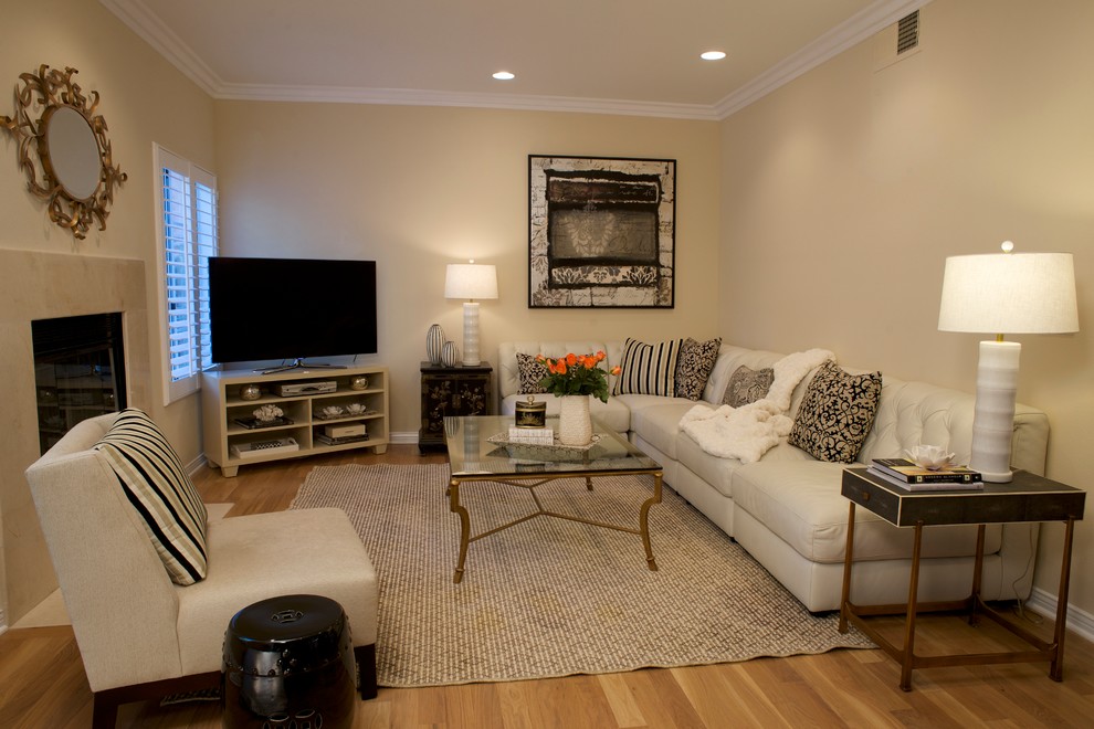 Cette image montre une salle de séjour traditionnelle de taille moyenne et ouverte avec un mur beige, un sol en bois brun, une cheminée standard, un manteau de cheminée en carrelage et un téléviseur indépendant.