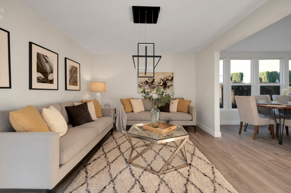 Imagen de sala de estar abierta contemporánea de tamaño medio sin chimenea y televisor con paredes blancas, suelo laminado y suelo gris