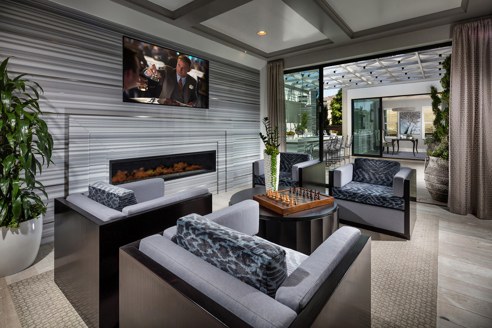 Design ideas for a medium sized contemporary open plan games room in San Diego with grey walls, light hardwood flooring, a ribbon fireplace, a tiled fireplace surround, a wall mounted tv and a feature wall.
